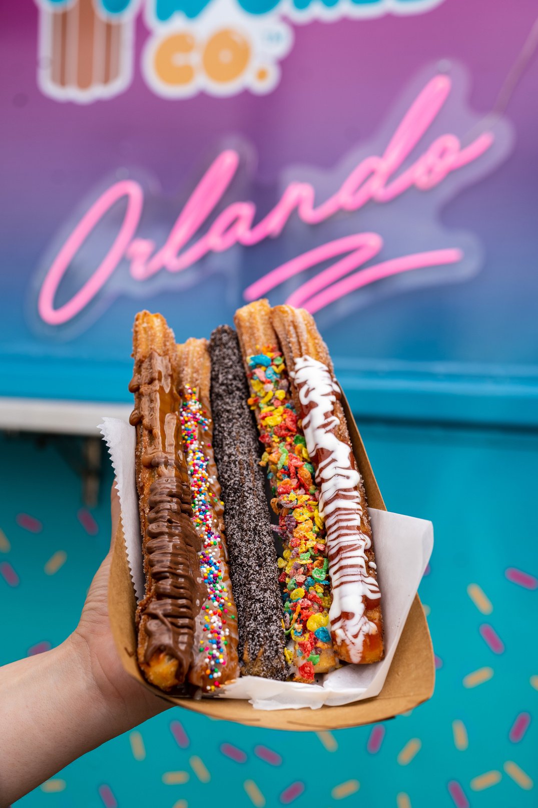 A Person Holding a Bunch of Churros with Toppings