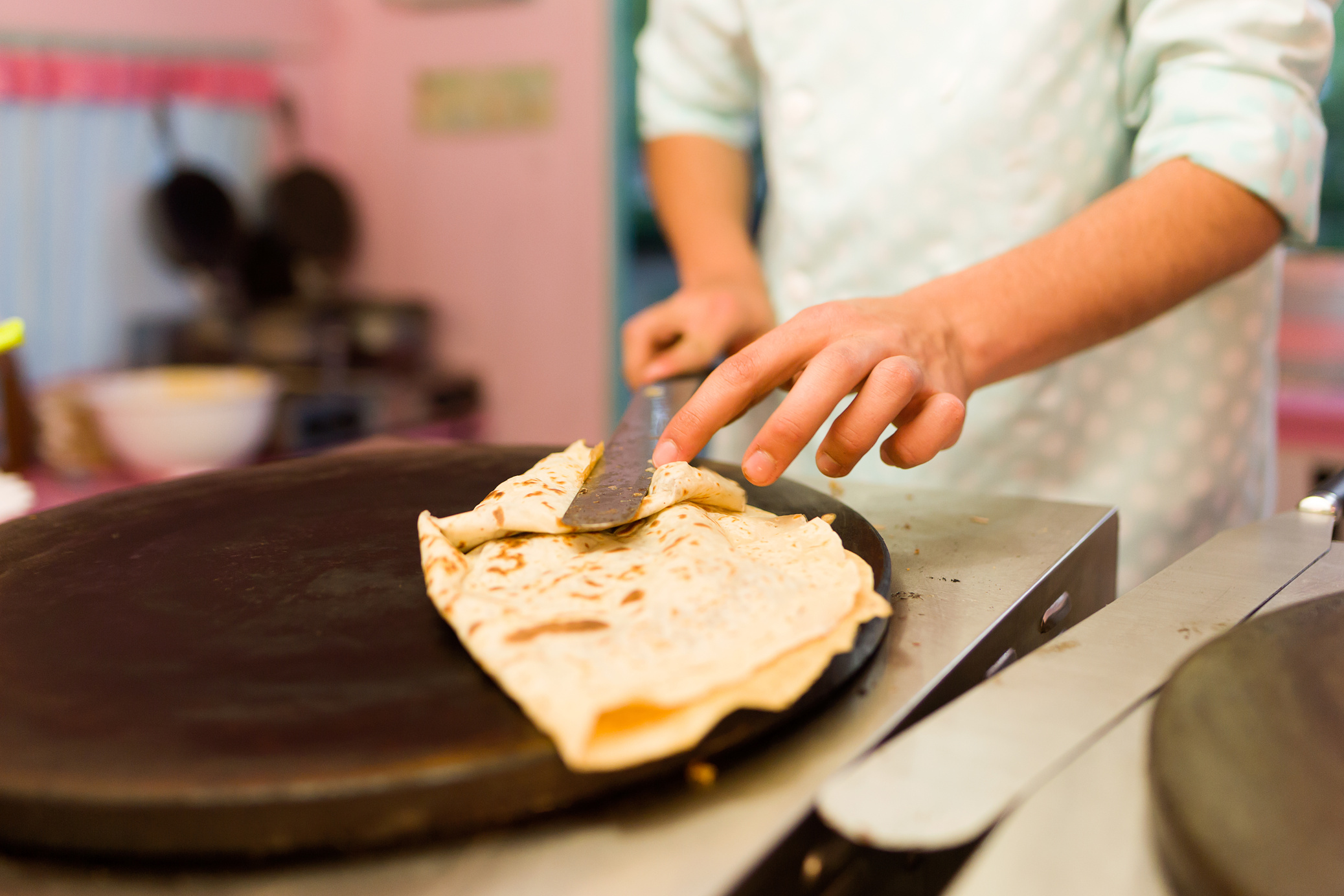 Young Man Cooking Crepes with Chocolate